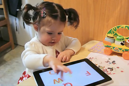 2 year old kid plays with iPad